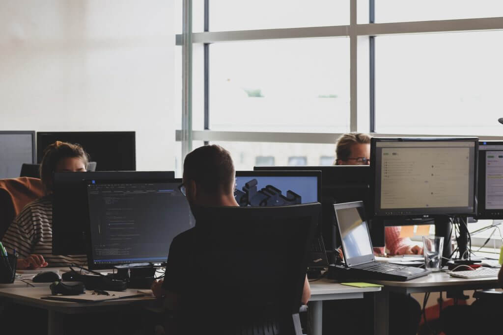 A team of developers working together demonstrates real reasons to use React in collaborative web development projects.