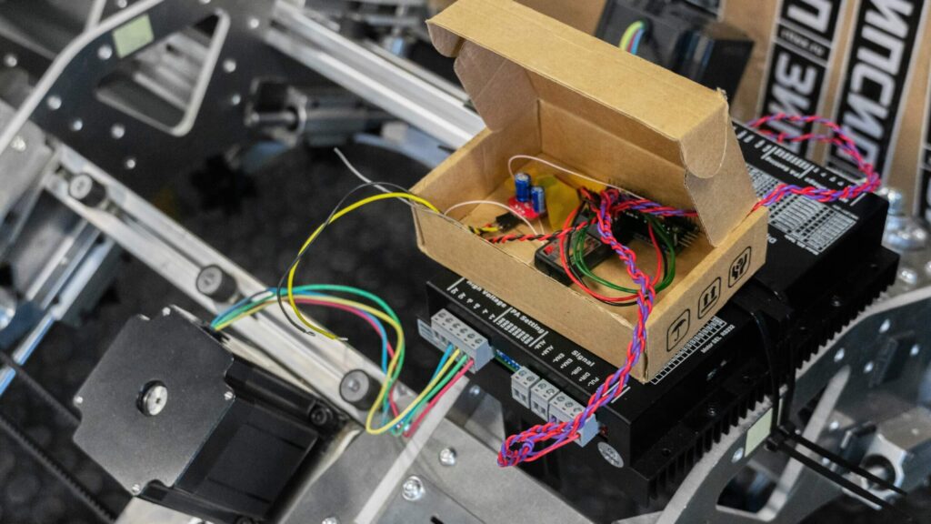 An early-stage hardware prototype with exposed wiring, a circuit board, and stepper motors, showing the physical testing phase of AI Proofs of Concept.