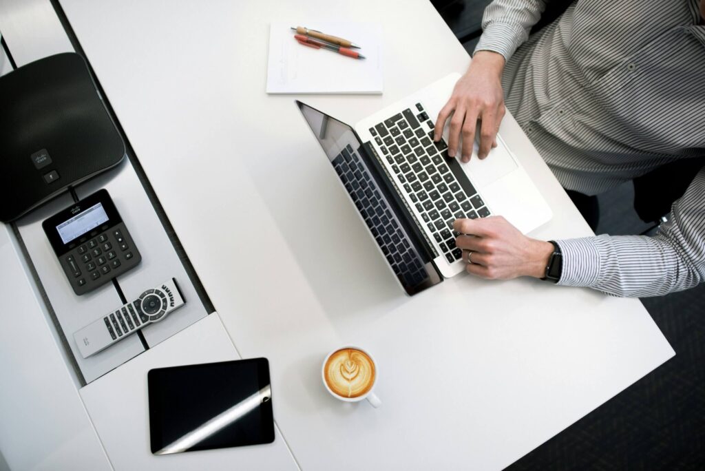 Enterprise AI adoption consultation setup with a professional working on a laptop at a meeting table, symbolizing strategic planning, readiness assessment, and implementation guidance.